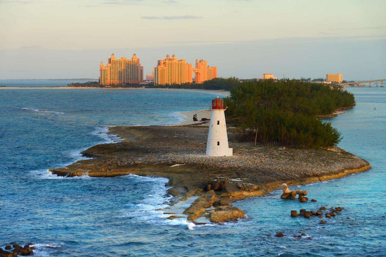 bahamas-g6733efeb4_1920 A picturesque white lighthouse with a red top stands on a small rocky island surrounded