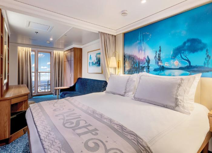 disney-cruise-line-1 A luxurious stateroom aboard a Disney Cruise Line ship featuring a queen-sized bed with premium