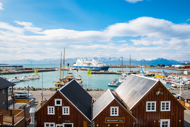 Cruise-Ship-in-Husavik A large cruise ship docked in the picturesque harbor of Húsavík, Iceland, with traditional