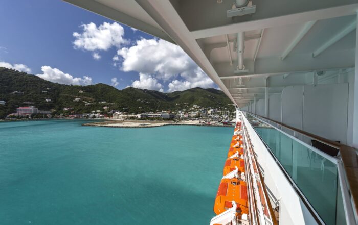 Scenic Caribbean view from a cruise ship balcony stateroom overlooking turquoise waters and lush islands scaled