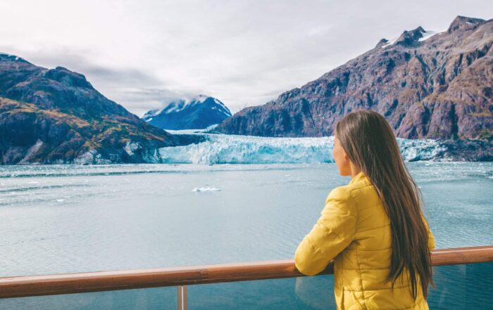 Woman on cruise balcony overlooking Alaskan glaciers