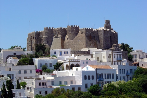 The Monastery of Saint John the Theologian overlooking whitewashed houses on the island of Patmos, Greece. A Greek island off the beaten path.