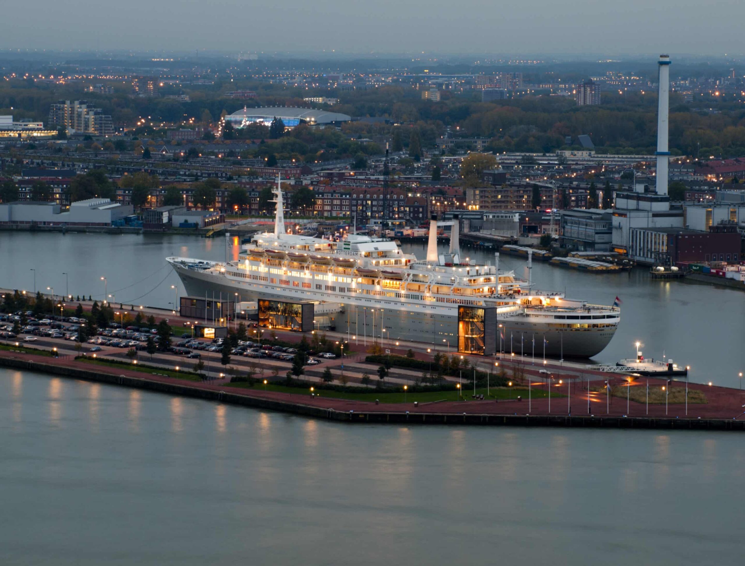 Large cruise ship docked in Rotterdam Harbor at dusk in the Netherlands, a popular embarkation point for the Netherlands by cruise journeys.