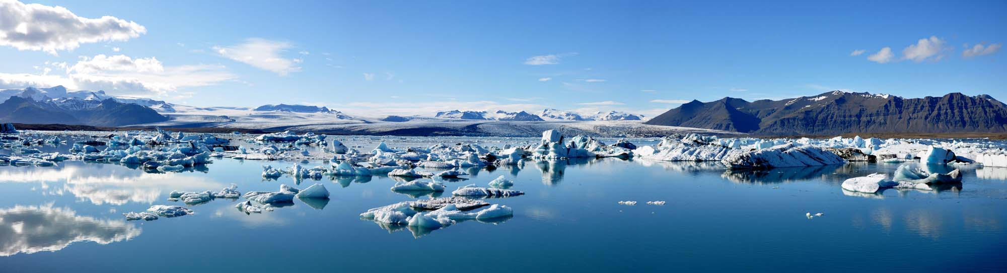 Jökulsárlón Glacier Lagoon, Iceland A stunning view of a turquoise lagoon in French Polynesia with overwater bungalows, palm trees, and lush volcanic peaks in the background.