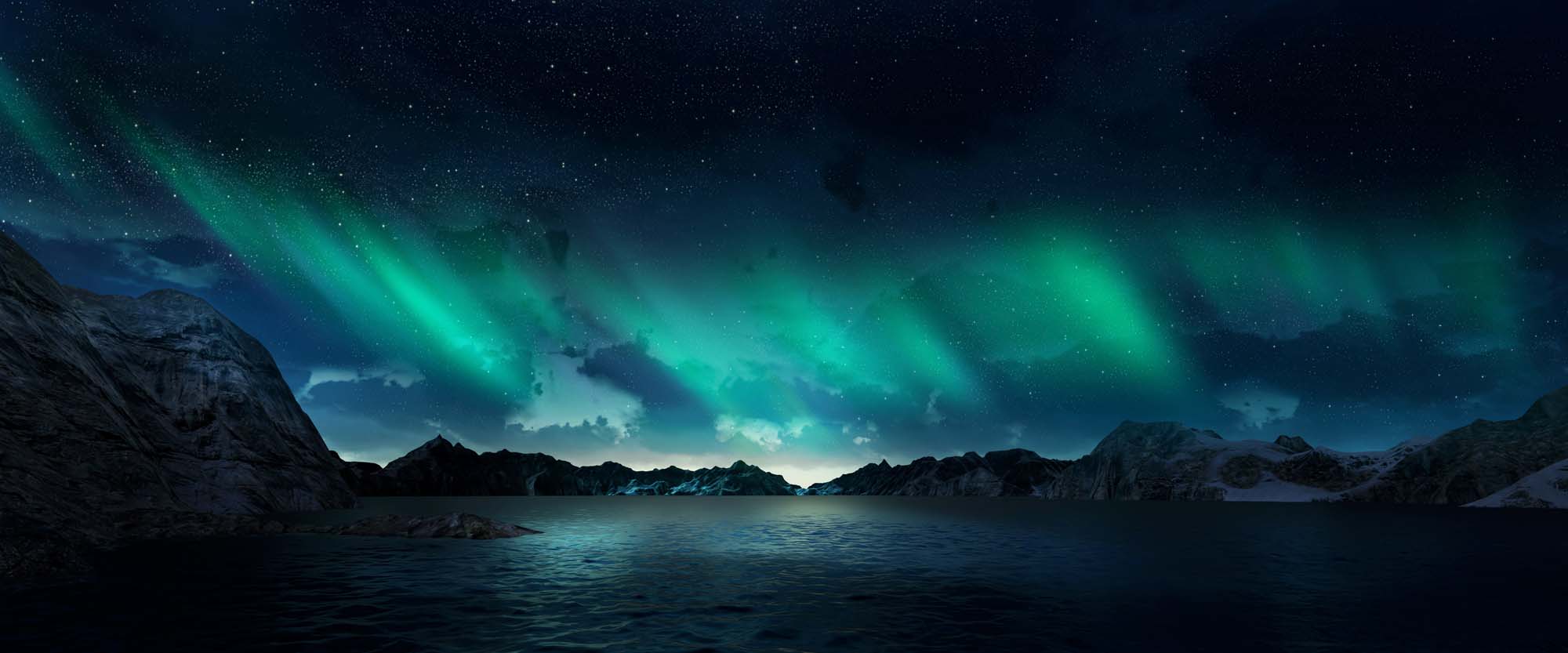 A stunning aurora borealis illuminates the night sky above a serene mountain lake with rocky shorelines and snow-capped peaks. The green and blue celestial lights dance across a starry dark sky, creating a mesmerizing natural spectacle.