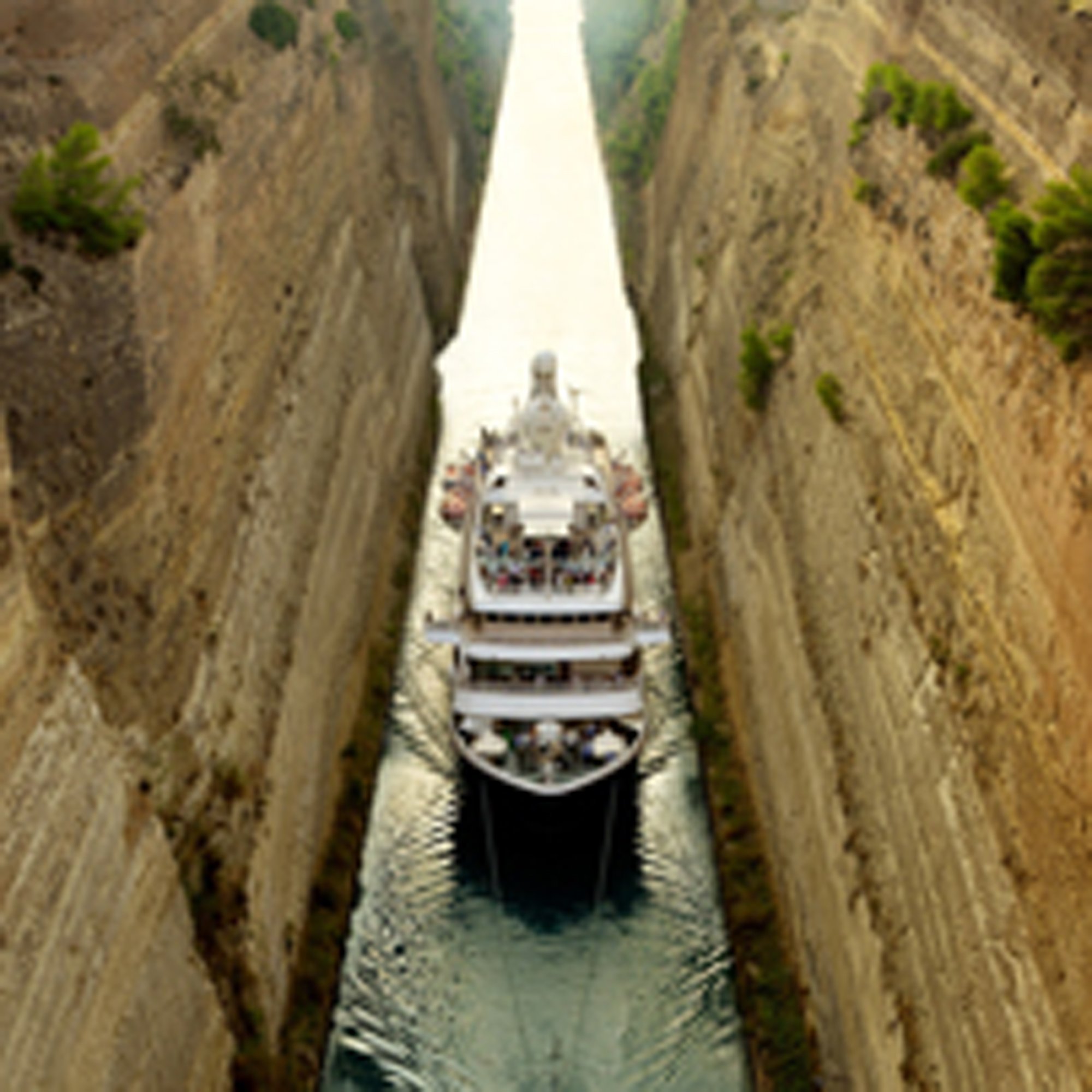 A large white cruise ship carefully navigates through an extremely narrow artificial waterway with high concrete walls on either side, showcasing remarkable maritime engineering and precision piloting in what appears to be a major canal lock system.