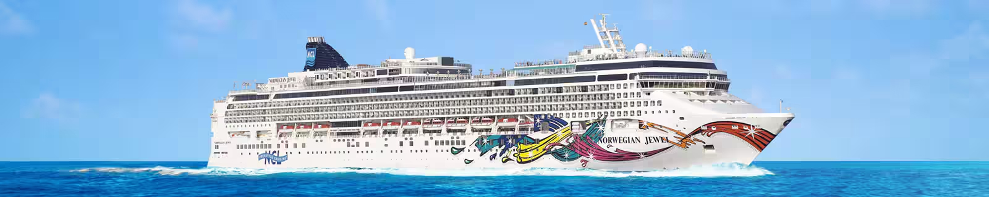 Norwegian Jewel Cruise Ship at Sea The Norwegian Jewel, a large modern cruise ship operated by Norwegian Cruise Line, sails through brilliant turquoise waters under clear blue skies. The vessel features distinctive colorful hull artwork and multiple decks with numerous portholes, characteristic of contemporary cruise ship design.