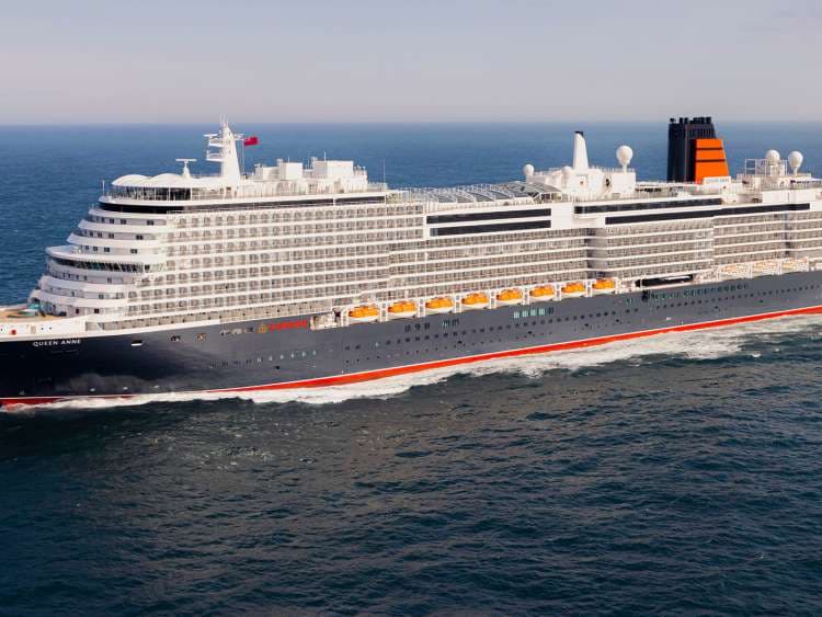 A large modern cruise ship with distinctive white superstructure and black hull featuring a striking red stripe along the waterline, photographed underway in open ocean waters during clear daylight conditions.