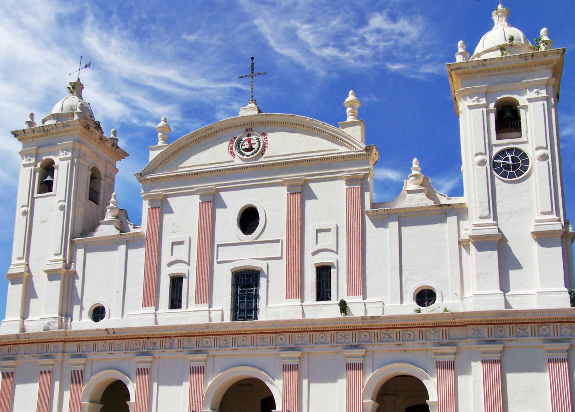 A stunning neoclassical cathedral featuring white marble facades with red-striped columns, twin