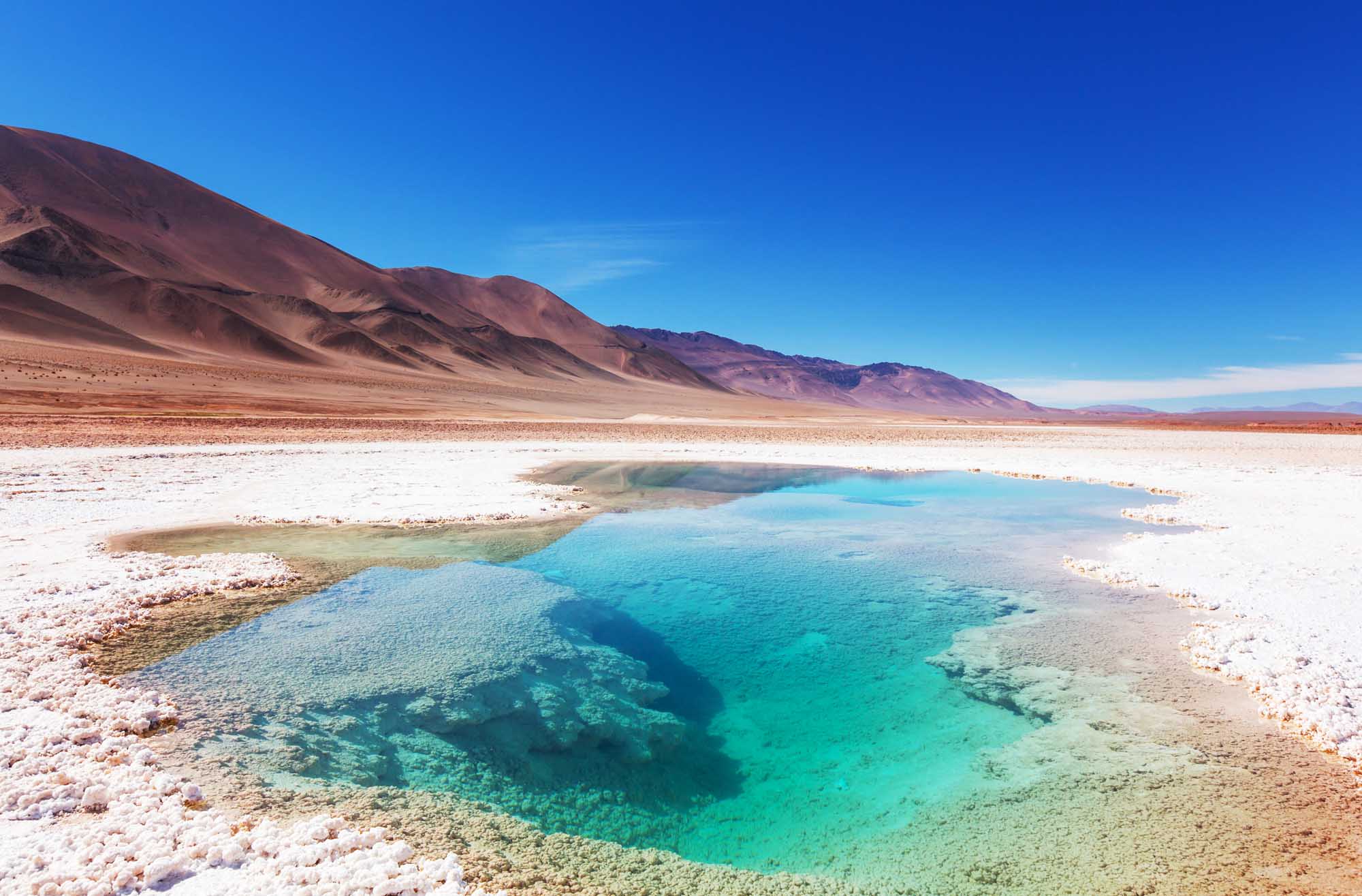 A stunning natural geothermal salt water pool glows brilliant turquoise and emerald against
