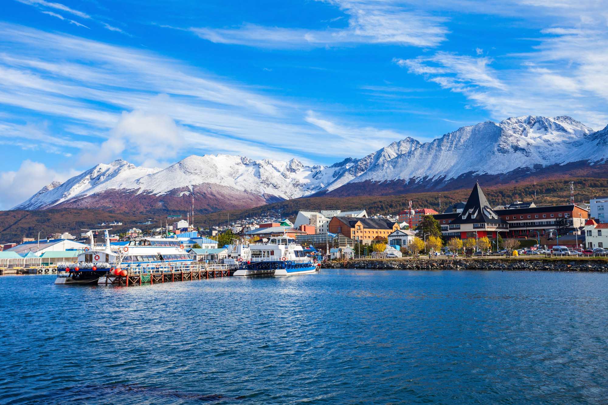 A scenic view of Ushuaia's bustling harbor in Tierra del Fuego, Argentina, featuring blue and white