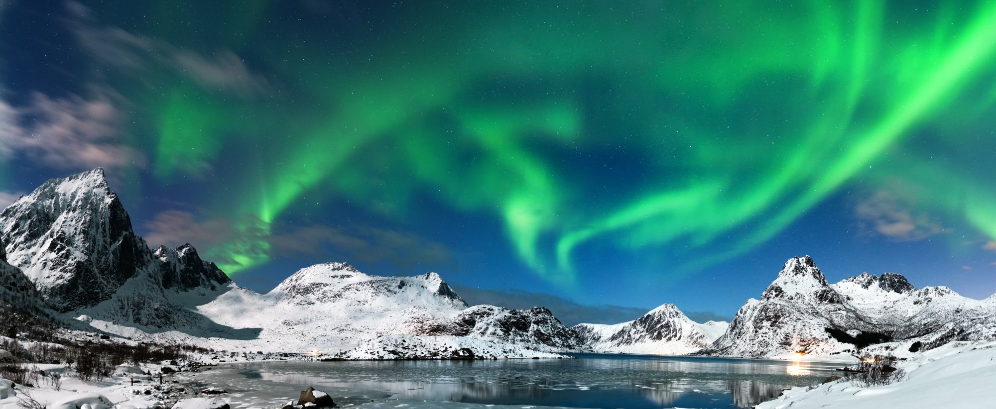 A breathtaking Arctic landscape featuring snow-capped mountains reflected in a pristine frozen