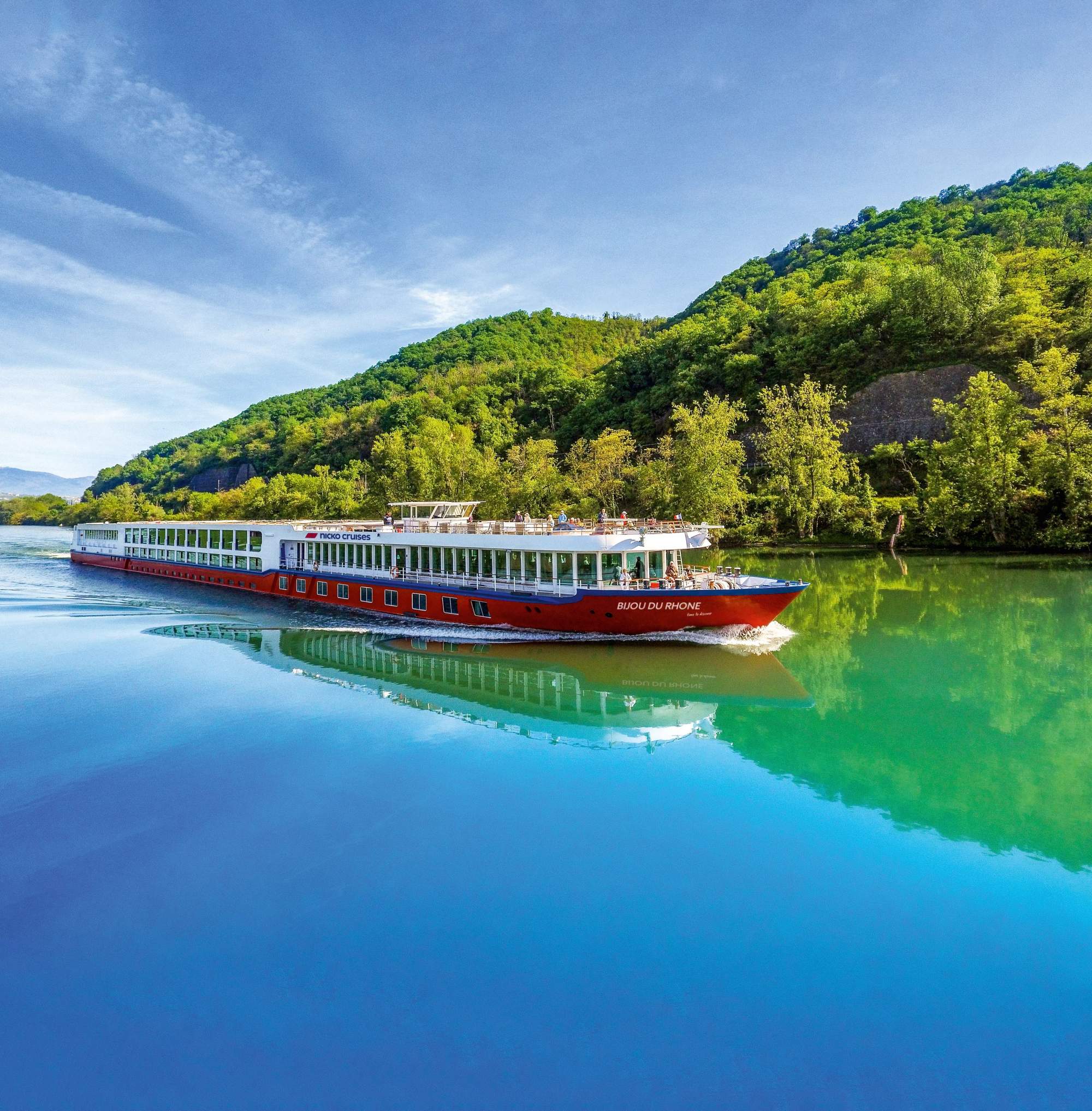 A scenic river cruise ship, the Bijou du Rhône, navigates the calm waters of the Rhône River