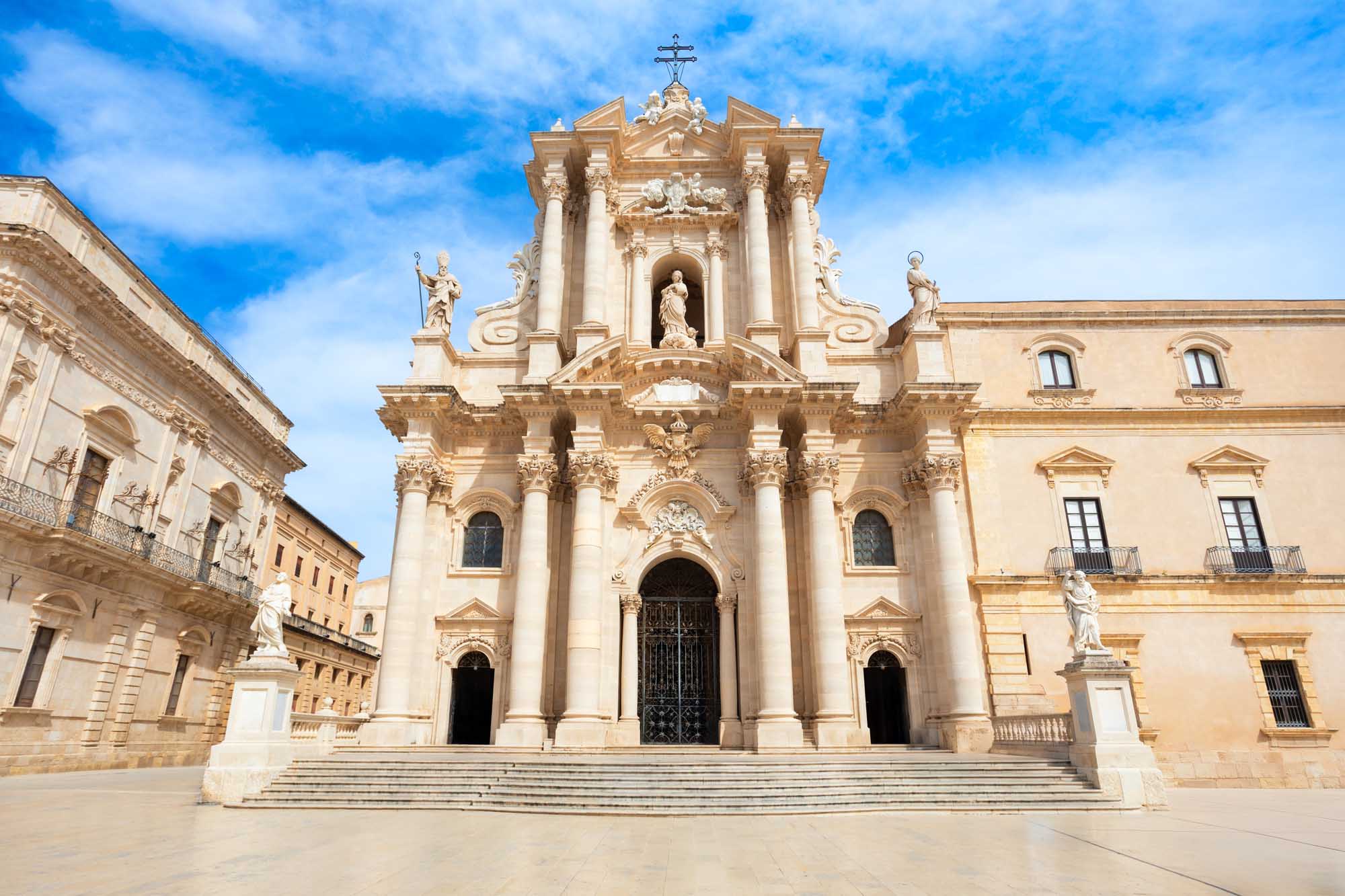 A stunning baroque cathedral facade in Syracuse, Sicily, featuring ornate limestone columns