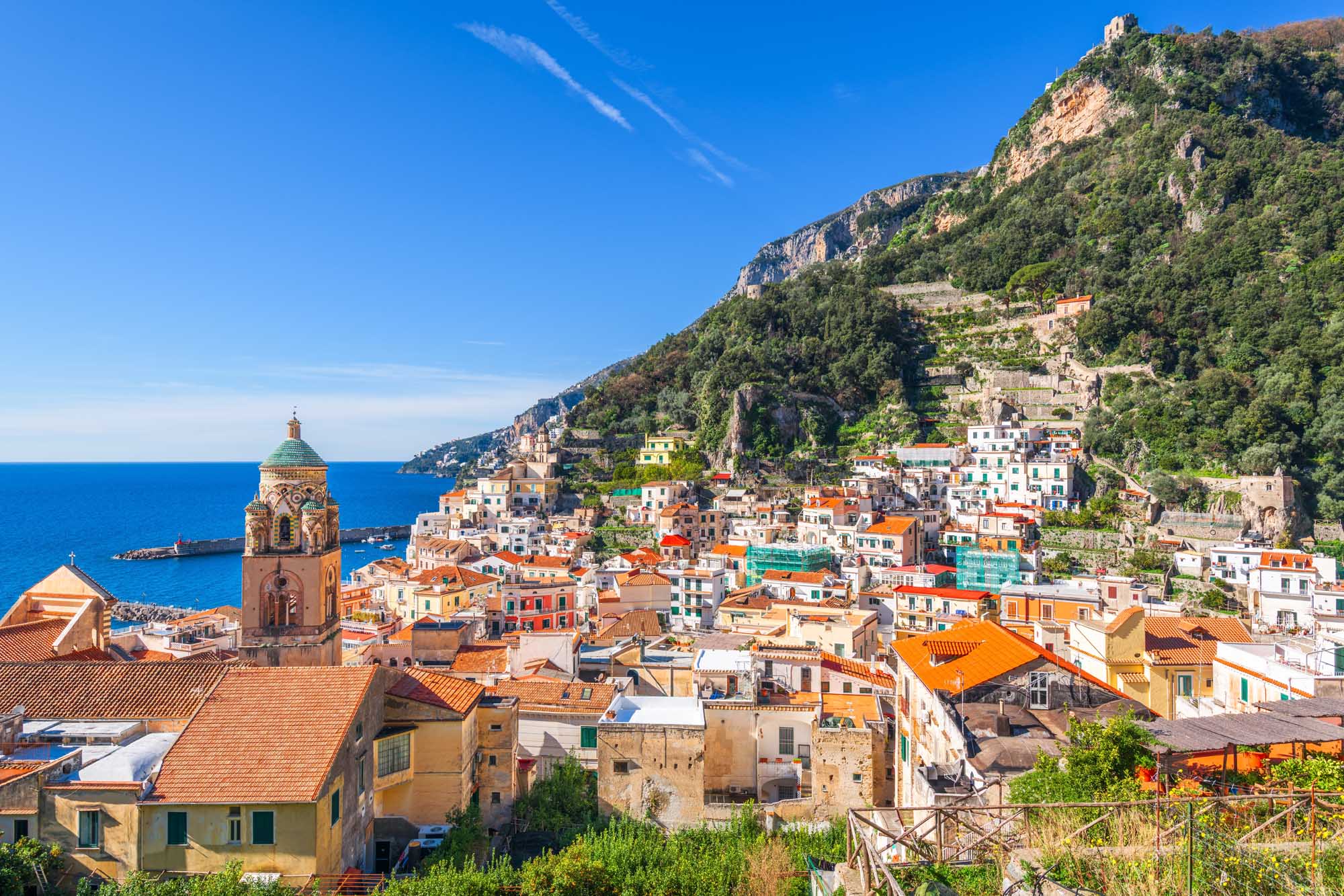 A stunning panoramic view of Amalfi, Italy, nestled dramatically along the Amalfi Coast