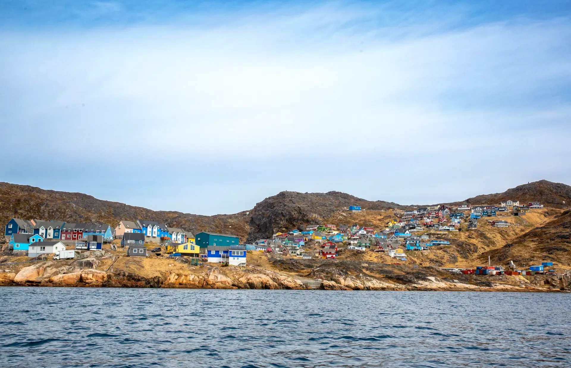 Colorful Greenlandic settlement with blue, red, and yellow houses on rocky coastal terrain