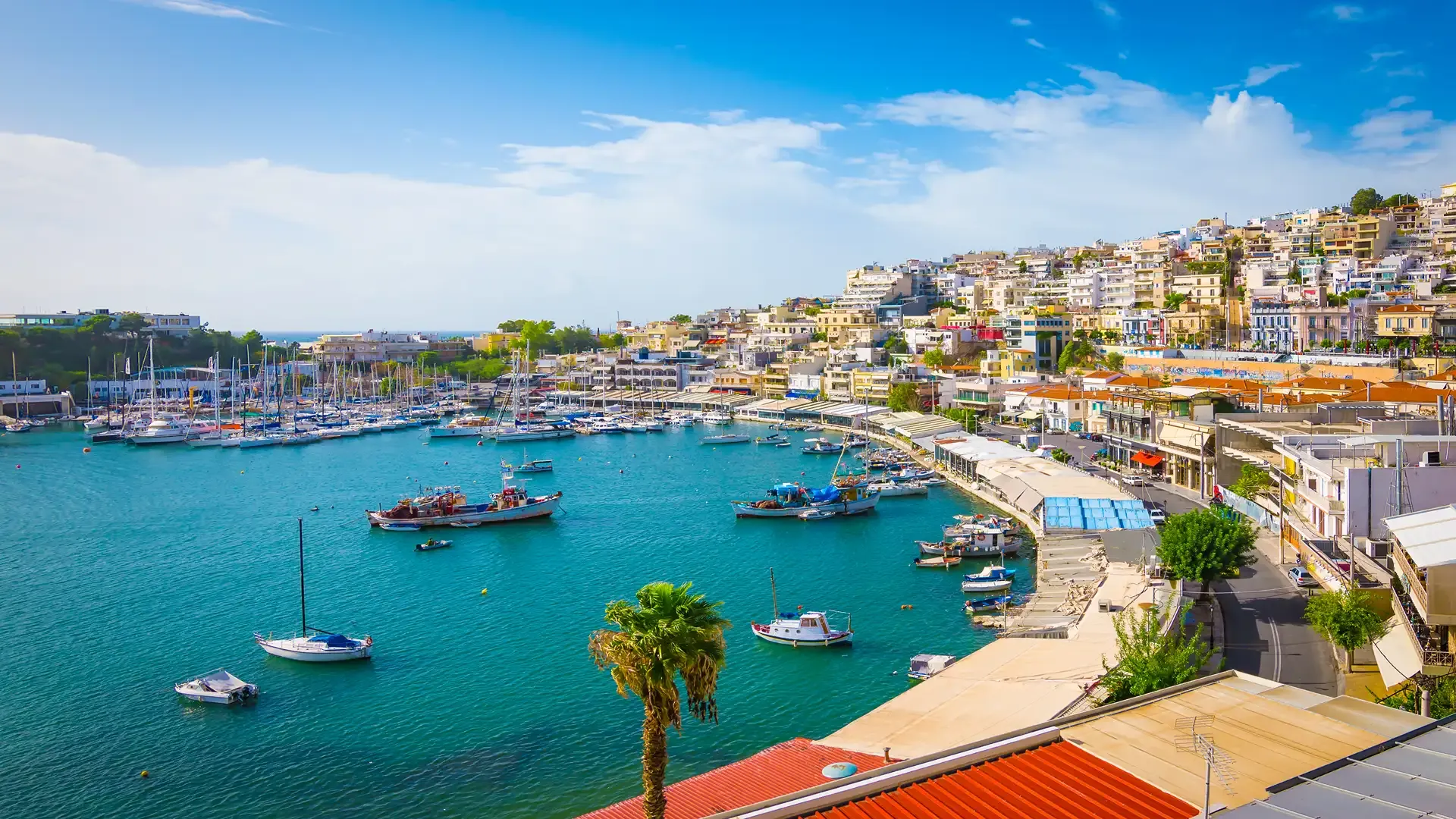 Colorful hillside harbor with moored boats in turquoise Mediterranean waters