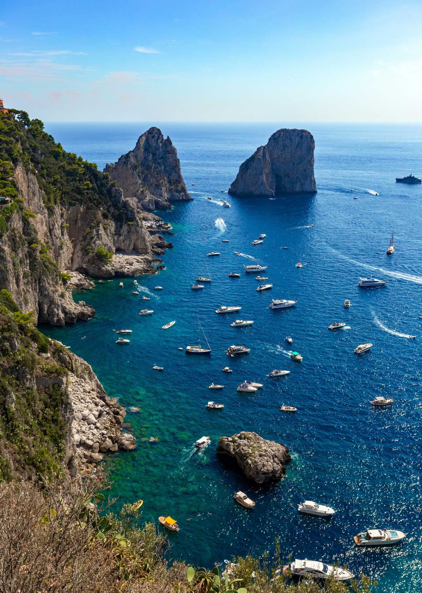 A stunning Mediterranean seascape featuring two iconic towering rock formations rising from