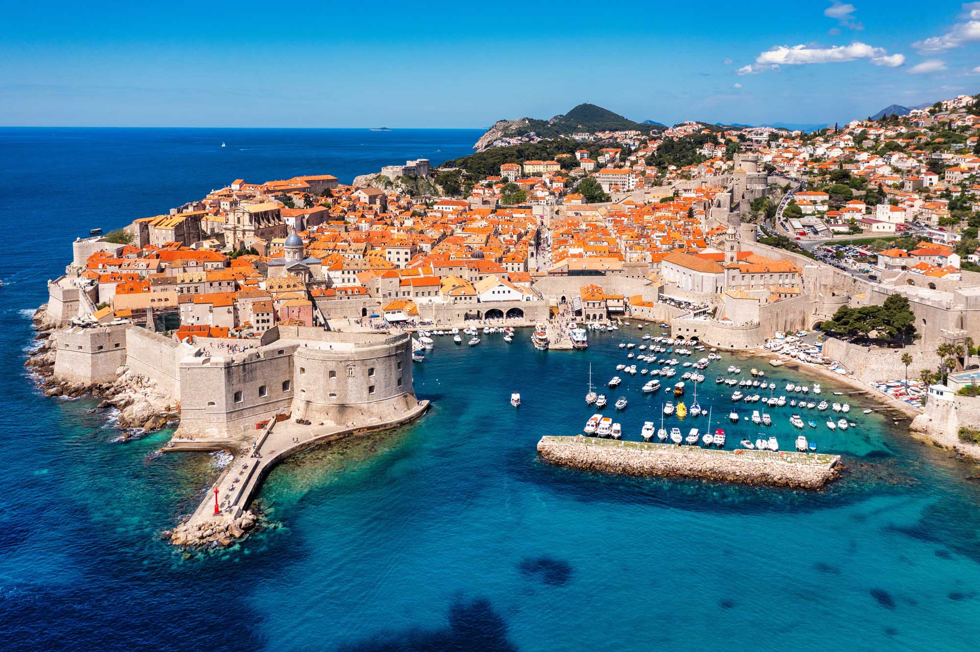 An aerial view of Dubrovnik's iconic medieval old town with distinctive orange-tiled roofs