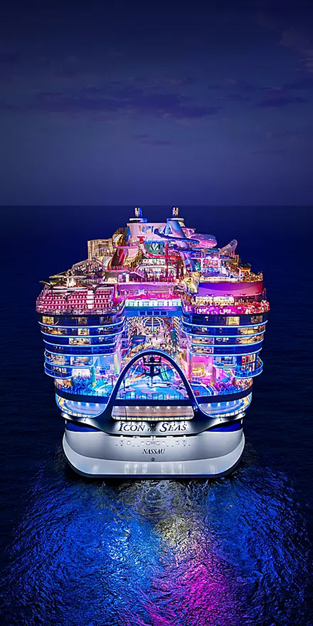 Icon of the Seas cruise ship illuminated at night from aerial view