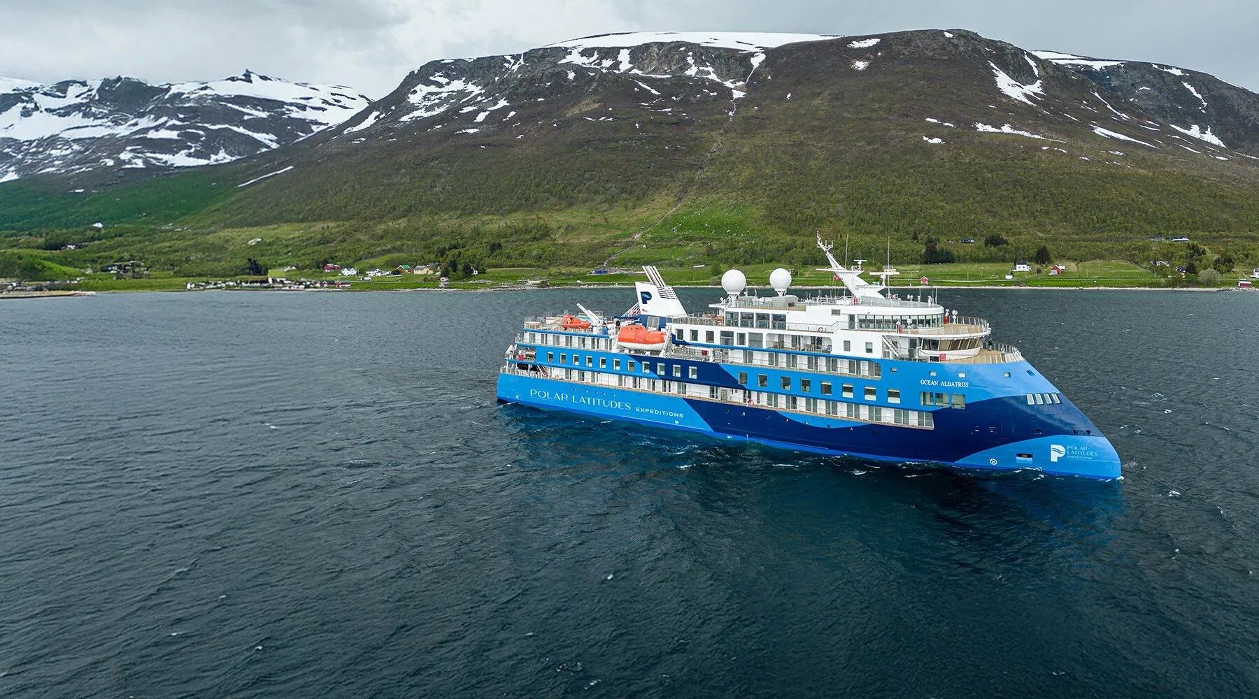 The Ocean Adventurer expedition cruise ship anchored in Arctic waters near snow-capped mountains