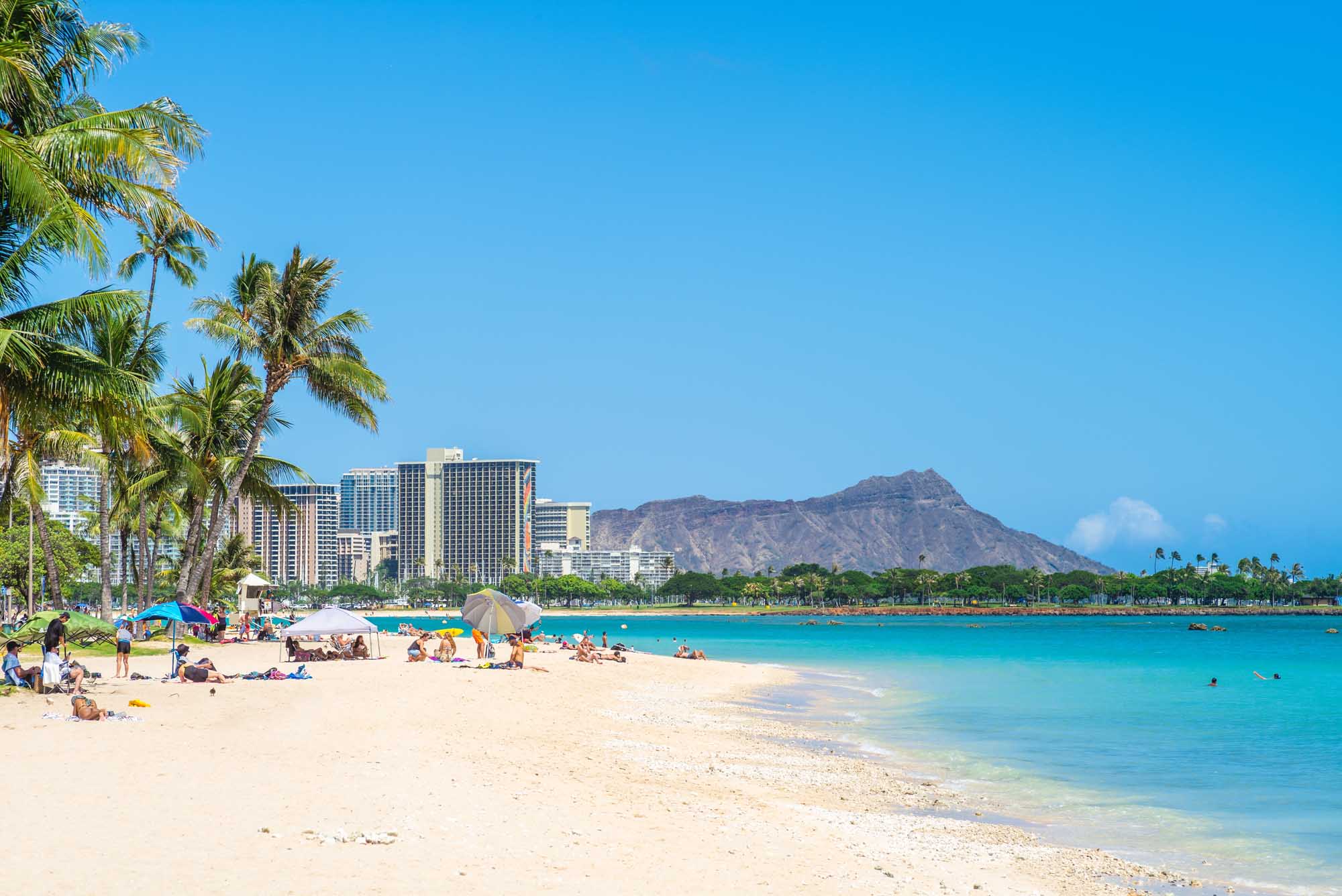 Waikiki Beach with Diamond Head Mountain and turquoise waters under clear blue sky