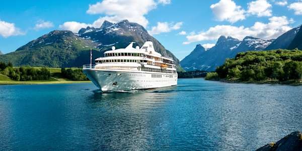 Windstar Cruises Star Explorer in Norwegian Fjord Windstar Cruises' Star Explorer navigating a scenic Norwegian fjord with mountain backdrop