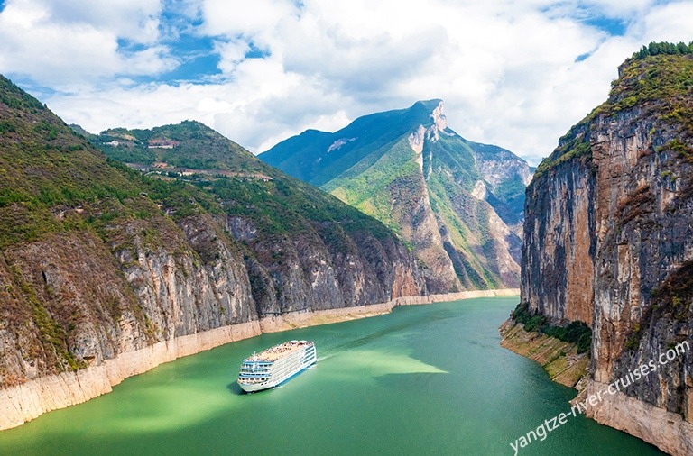 Yangtze River Cruise Through Three Gorges Canyon A luxury river cruise ship navigates the emerald-green waters of the Yangtze River through