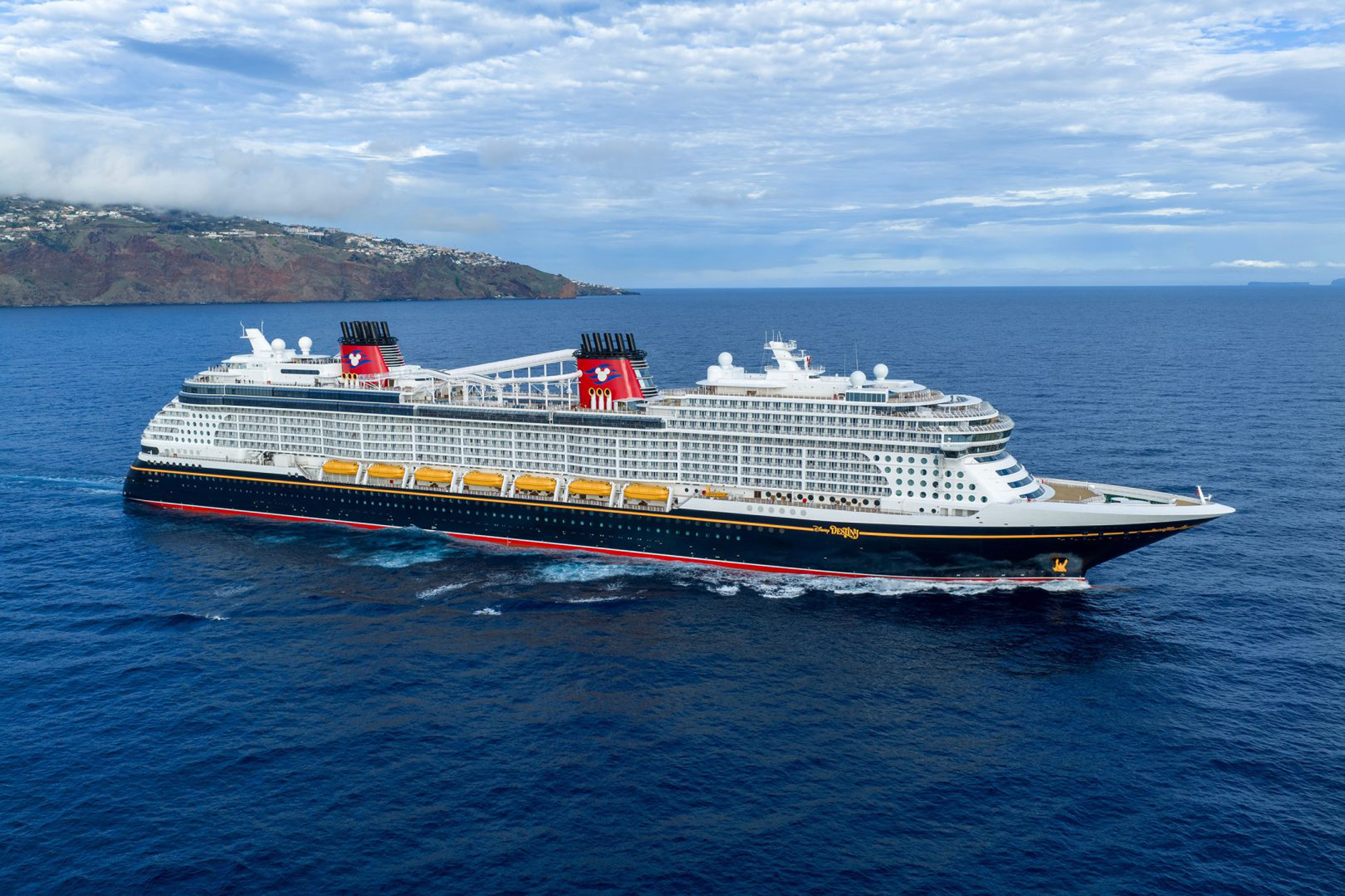 Disney Cruise Line Ship at Sea A large modern Disney Cruise Line vessel anchored in deep blue waters off a volcanic island