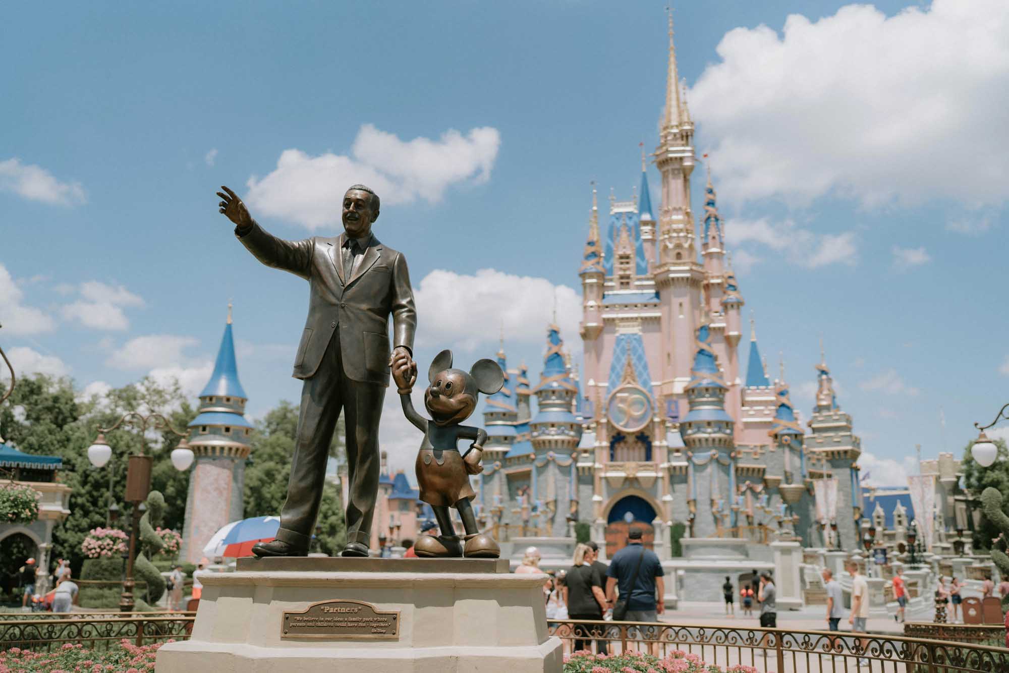 Magic Kingdom Castle with Walt Disney Statue An iconic statue of Walt Disney stands with Mickey Mouse in front of Cinderella Castle at Magic