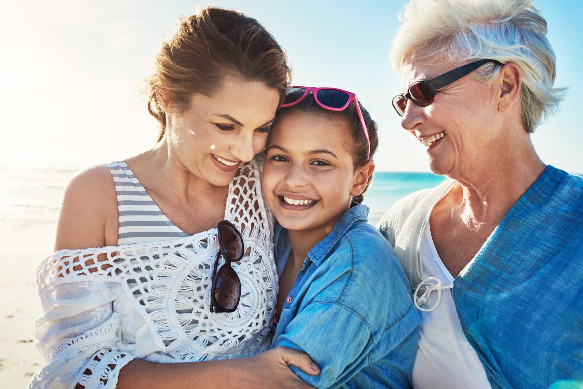 Multigenerational Family Beach Portrait A joyful multigenerational family portrait featuring a grandmother, mother, and young daughter