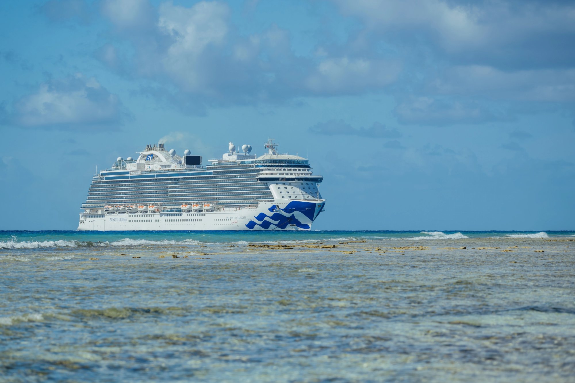 Princess Cruises Enchanted Princess Full Exterior View A striking full-length view of the Enchanted Princess cruise ship anchored offshore in tropical