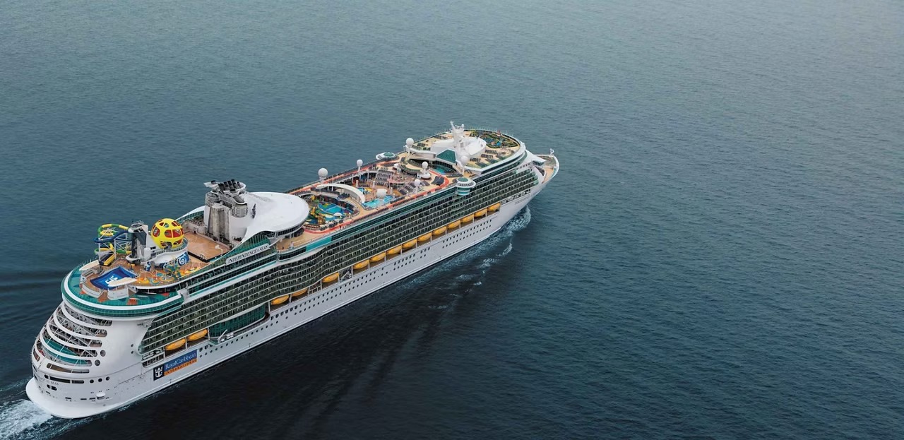 Royal Caribbean Independence of the Seas Cruise Ship An aerial view of a large Royal Caribbean cruise ship sailing through calm blue waters. The vessel