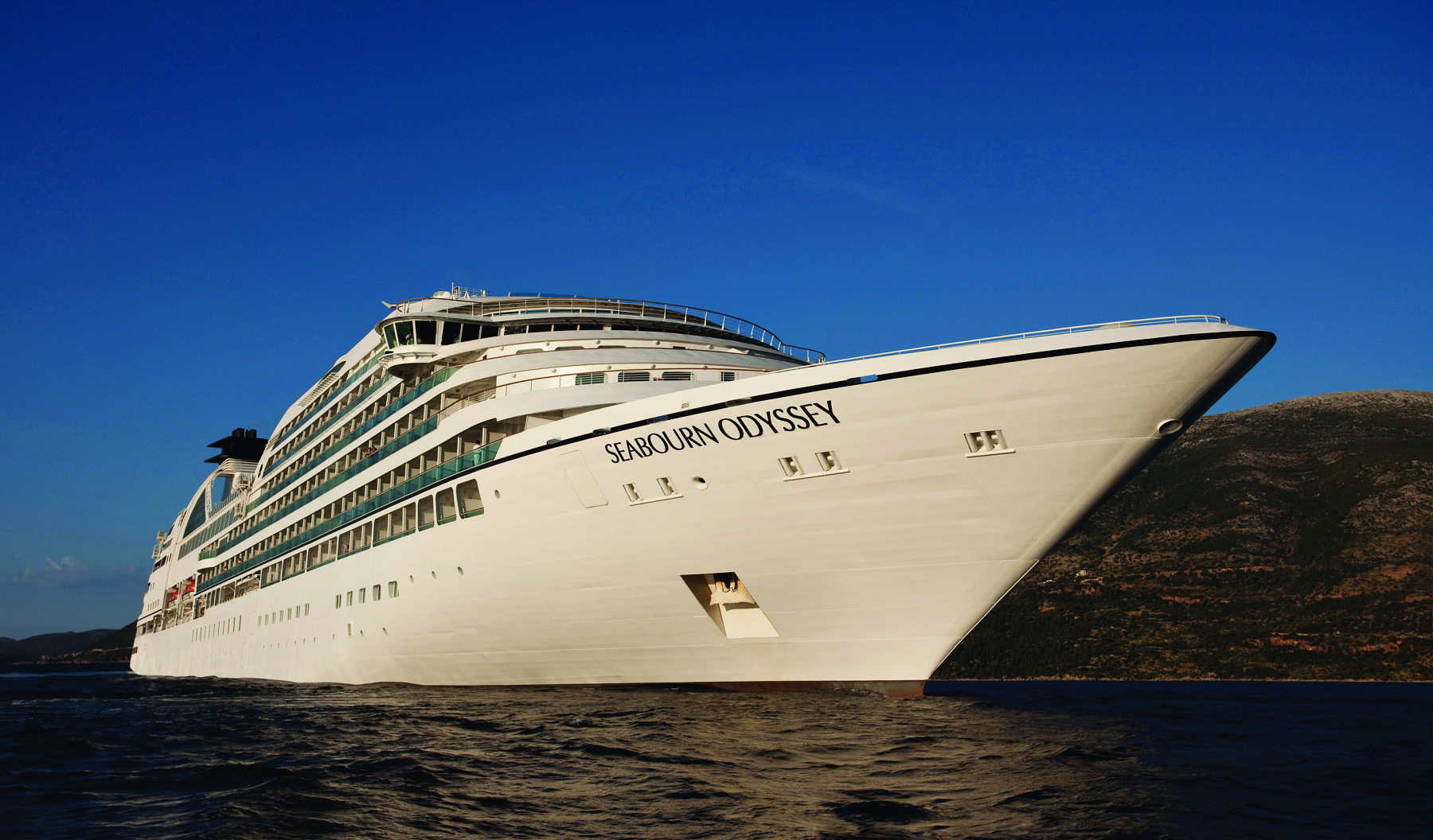Seabourn Odyssey Cruise Ship at Anchor The Seabourn Odyssey, an ultra-luxury cruise ship, is pictured anchored in calm waters near a rocky