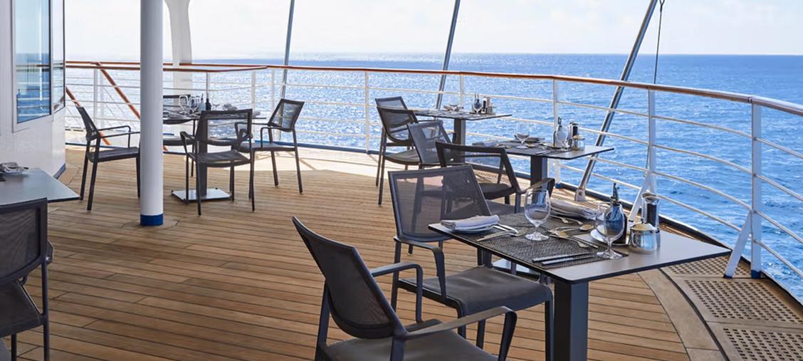 Silversea Luxury Dining Deck Overlooking Open Ocean An elegant outdoor dining and lounge area aboard a Silversea luxury cruise ship, featuring