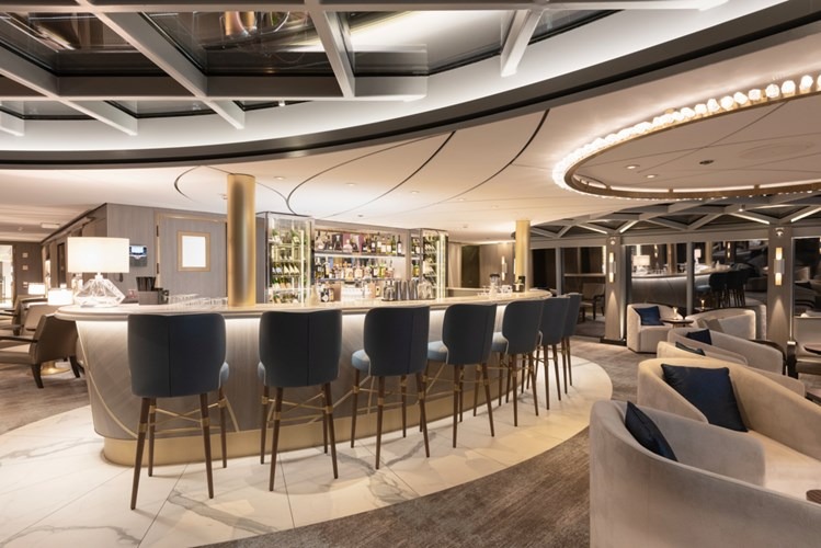 A sophisticated and modern lounge bar aboard a Uniworld river cruise ship, featuring an elegant