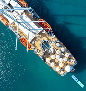 Windstar Cruises Small Ship Aerial View An overhead aerial view of a Windstar Cruises small luxury ship docked in clear turquoise waters